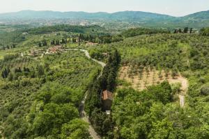 une vue aérienne sur une forêt avec une maison sur une colline dans l'établissement Chiesino Dei Vaioni, à Pistoia