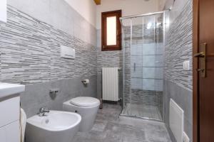 Un baño con inodoro, lavabo y ducha. en Gardaland Holiday Home*****, en Castelnuovo del Garda 31 fotos más