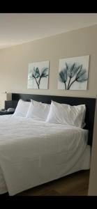 a bedroom with a white bed with three pictures on the wall at Richland Inn and Suites in Richland
