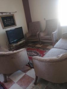 a living room with two couches and a flat screen tv at غير متاحه للايجار الرجاء عدم الحجز لانها غير متوفره in Alexandria