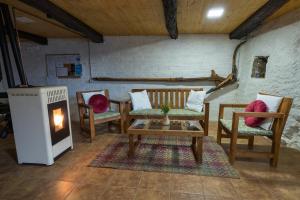 a living room with chairs and a table and a fireplace at Fogar do Pumar in Pantón