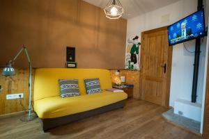 パントンにあるFogar do Pumarのリビングルーム(黄色のソファ、テレビ付)