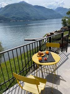 una mesa amarilla y sillas en un balcón con vistas al lago en Appartamento Riviera, en Cremia