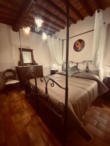 1 dormitorio con cama con dosel y suelo de madera en Locazione turistica ex Le Casette Di Cedromonte, en Panicale