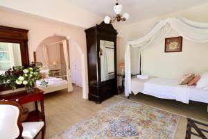 a bedroom with a canopy bed and a dresser at Kemerbag 29 Guest House 12 Yaş Üstü in Bozcaada