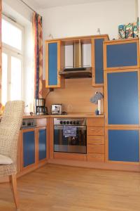 una cucina con armadi blu e un piano cottura con forno di Urlaub im Herzen von Celle a Celle