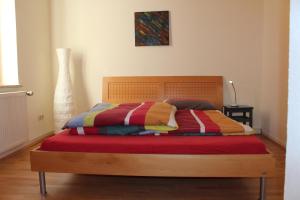 ein Schlafzimmer mit einem Holzbett mit einer bunten Decke in der Unterkunft Urlaub im Herzen von Celle in Celle