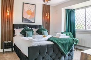 een slaapkamer met een groot bed met groene accenten bij Private driveway - close to Warwick Racecourse & Warwick Castle!! in Warwick