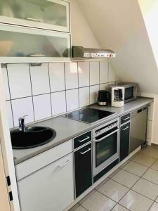 una pequeña cocina con fregadero y microondas en 2 Zi Whg auf 2 Etagen DG, Aufzug, Balkon, en Brunswick