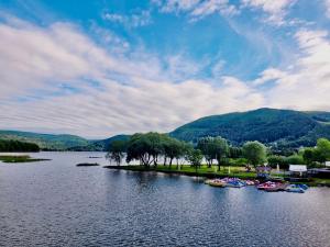 a group of boats on a lake with mountains in the background at Studio 2-pokojowe z balkonem z widokiem na góry in Międzybrodzie Żywieckie