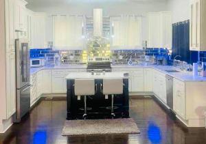 a large kitchen with white cabinets and a sink at 1966-Huge 4BR w/Rooftop Veranda in Decatur