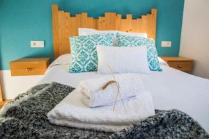ein Schlafzimmer mit einem Bett mit Handtüchern darauf in der Unterkunft Fogar do Pumar in Pantón