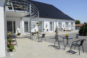 un patio avec des tables et des chaises à côté d'un bâtiment dans l'établissement Hotel CoCo Aps, à Esbjerg