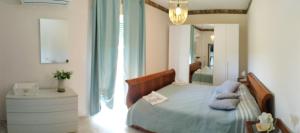 a bedroom with a bed with blue pillows and a mirror at Agriturismo l' Annunziata in Lizzano