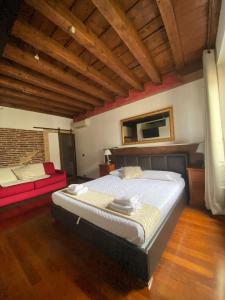 een slaapkamer met een groot bed en een rode bank bij Roma Loft in Verona