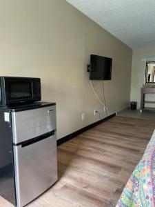 a room with a microwave and a refrigerator and a tv at DELUXE INN in Warsaw