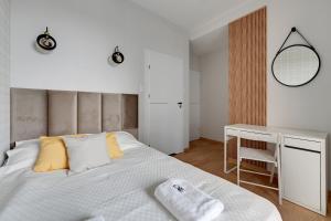 sypialnia z białym łóżkiem i biurkiem w obiekcie MS Apartments Motława I w Gdańsku