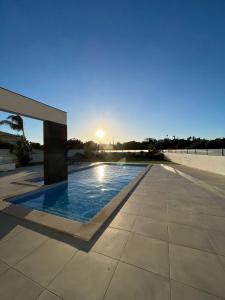 a swimming pool with the sunset in the background at Villa Sunset in Guia