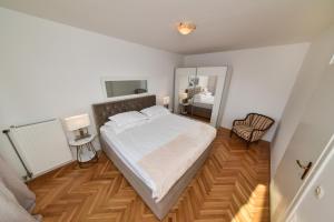 a bedroom with a large bed and a mirror at APARTMENT MEMORY in Zadar