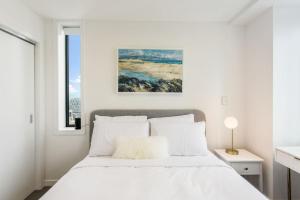 a white bedroom with a bed and a window at The Perfect Premium City Sanctuary - Netflix-WiFi in Auckland