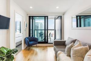 a living room with a couch and a large window at The Perfect Premium City Sanctuary - Netflix-WiFi in Auckland