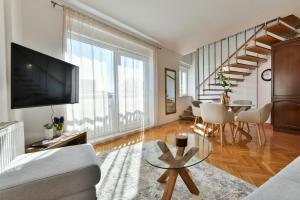 a living room with a couch and a tv and a table at APARTMENT MEMORY in Zadar
