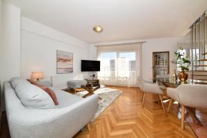 a living room with a white couch and a table at APARTMENT MEMORY in Zadar +8 photos