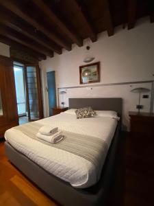 um quarto com uma cama grande e toalhas em Roma Loft em Verona