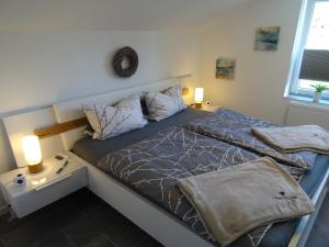 ein Schlafzimmer mit einem Bett und einem Nachttisch mit zwei Lampen in der Unterkunft Sammy's FeWo in Hahnenklee-Bockswiese