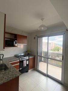 eine Küche mit offener Tür zum Balkon in der Unterkunft Las gardenias in San Salvador de Jujuy