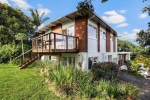 a house with a deck and a balcony at Coastal Calm is near to the Beach with BBQ in Auckland