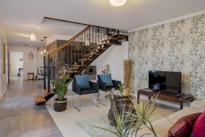 - un salon avec un escalier et un canapé dans l'établissement Villa Casa Das Orquideas by Villa Plus, à Estreito da Calheta