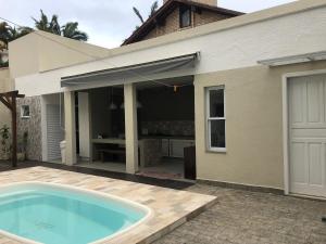 a swimming pool in front of a house at Solar dos Cataventos: Linda Casa com Piscina e Jacuzi in Florianópolis