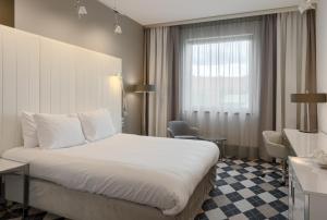 a hotel room with a bed and a window at Qubus Hotel Bydgoszcz in Bydgoszcz
