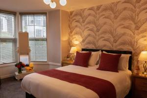 a bedroom with a large bed with red pillows at Biskey Bowness in Bowness-on-Windermere