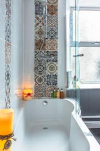 een badkamer met een bad en een glazen douche bij Biskey Bowness in Bowness-on-Windermere