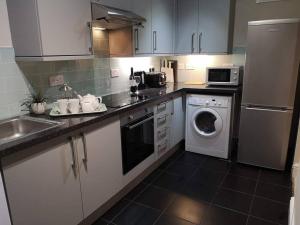 a kitchen with a sink and a washing machine at Biskey Bowness in Bowness-on-Windermere