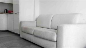 a white couch in a room with a kitchen at Nicely furnished 1 bedroom apartment in Gzira in Il-Gżira
