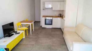 a living room with a couch and a kitchen at Nicely furnished 1 bedroom apartment in Gzira in Il-Gżira