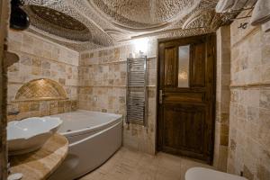 於爾居普的住宿－Konak Bezirhane Cave Otel，带浴缸和盥洗盆的浴室