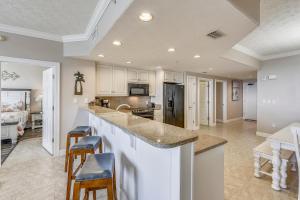 a kitchen with a counter and chairs in a room at Treasure Island 2103 in Panama City Beach
