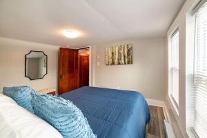 Un dormitorio con una cama azul y una ventana en Tons of parking with direct snowmobile access from home en Gorham