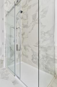 a shower with a glass door in a bathroom at Villa Dante By Denstays in Montréal