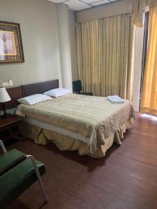 a hotel room with a bed and a chair at Hotel Rizzo in Guayaquil