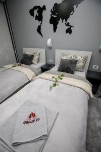Un pat sau paturi într-o cameră la APARTMAN DELUX 20