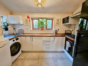 a kitchen with white cabinets and a window at Victorian Superior Property in London