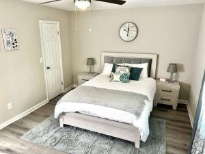 1 dormitorio con 1 cama y reloj en la pared en Cozy Modern Farmhouse miles away from Lake Lanier, en Buford