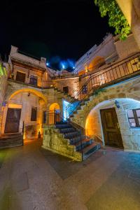 於爾居普的住宿－Konak Bezirhane Cave Otel，一座建筑,前方有楼梯,晚上