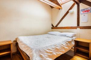 Cama en habitación con 2 mesas de madera en Hostal La Suite, en Sangolquí