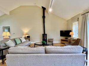 a living room with two couches and a tv at Beaufort Barn by Inspire Stays in Bignor